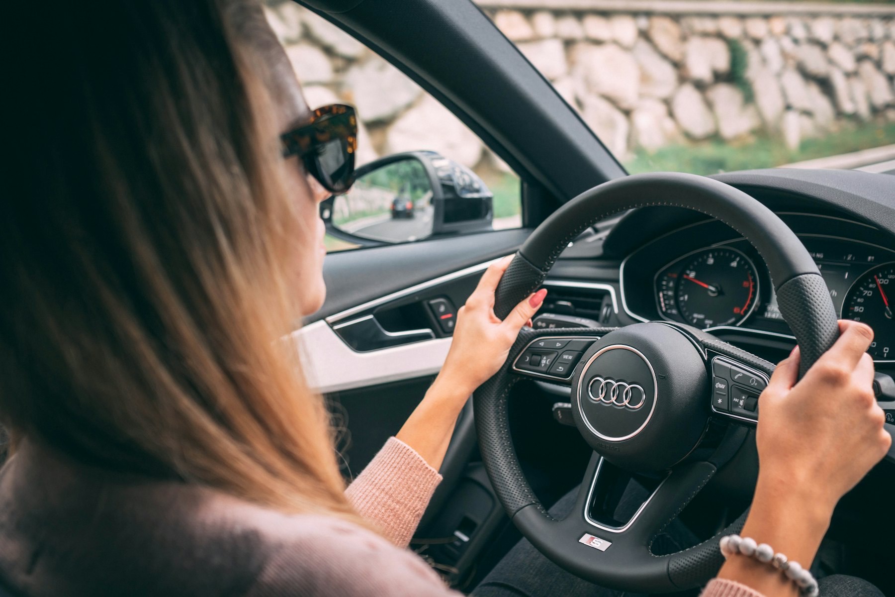 A driver on an open road seen from the passenger seat