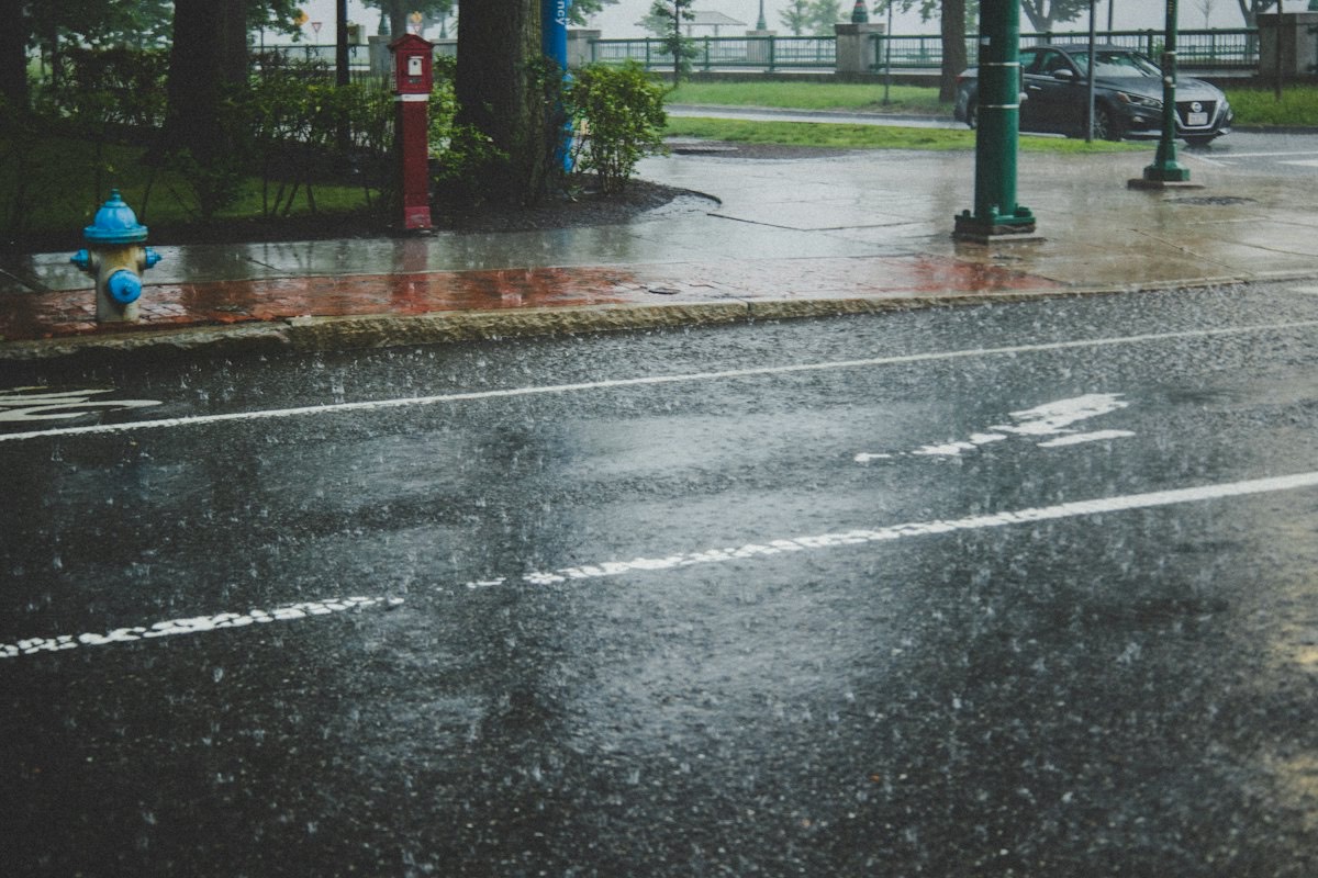 A wet road surface shining under grey skies